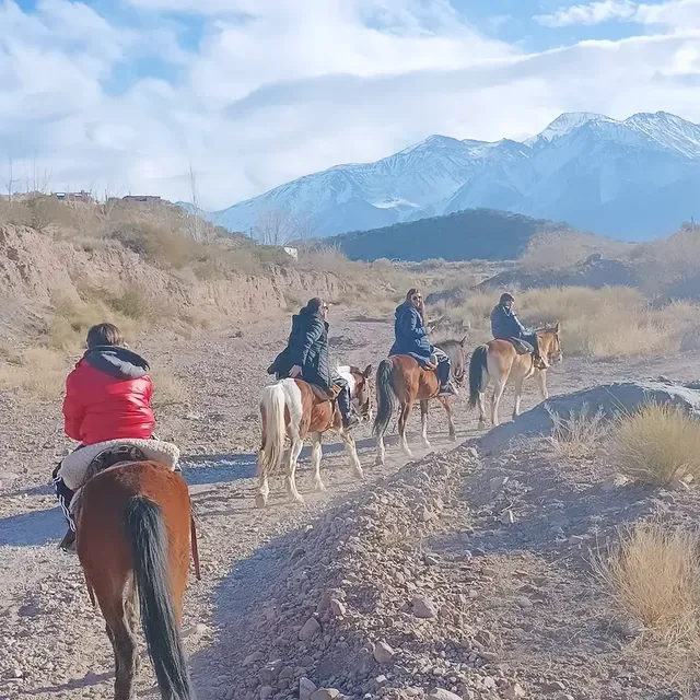 Group horseback riding toward the Andes